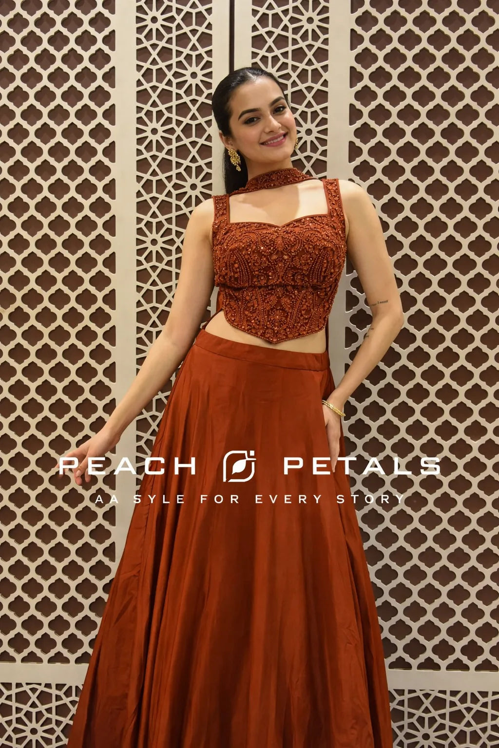 Woman in a rust-colored traditional outfit with 'Peach Petals' branding.