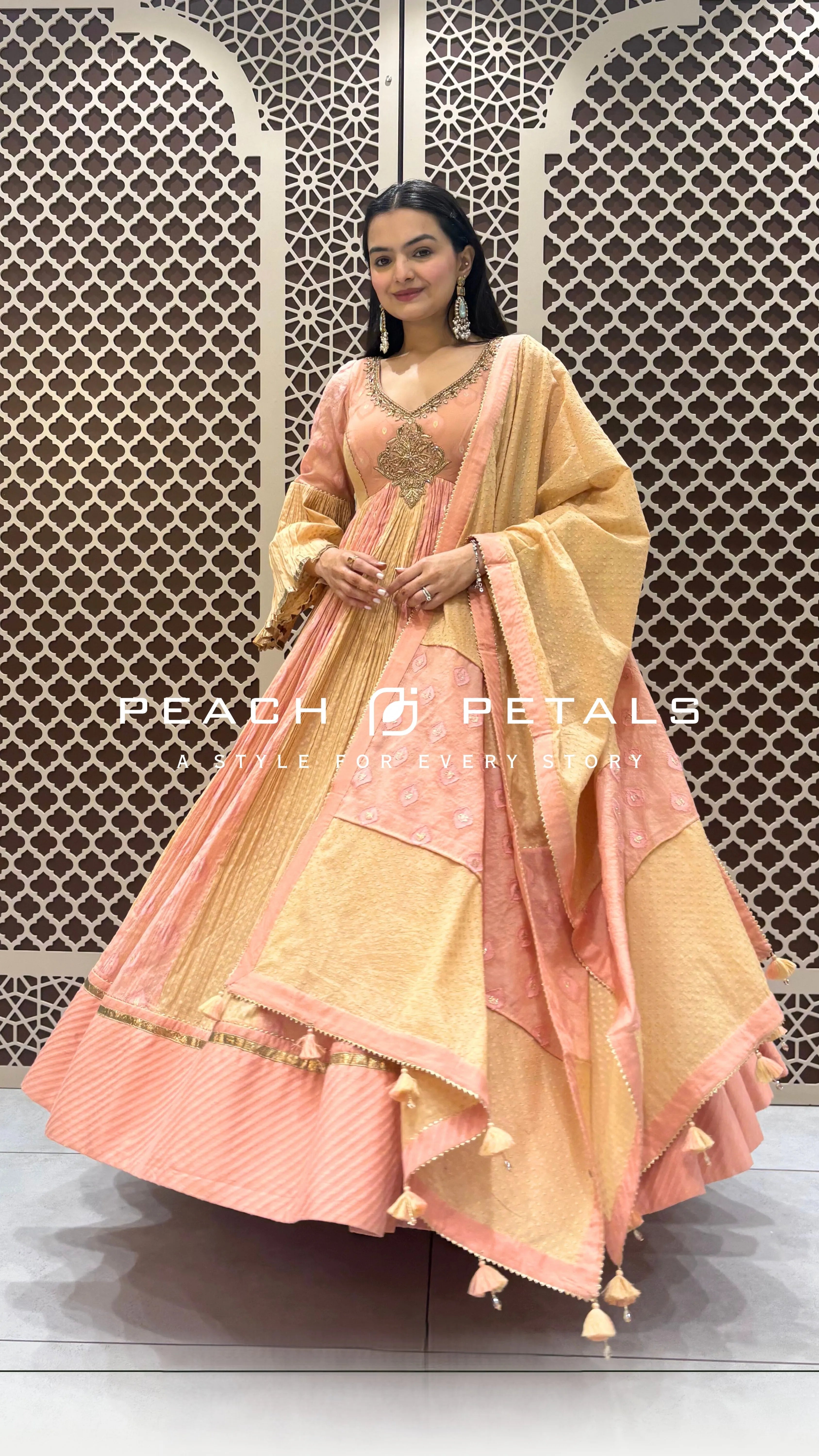 Peach and gold silk checkered Anarkali suit with heavy neck embroidery and a tasselled dupatta.
