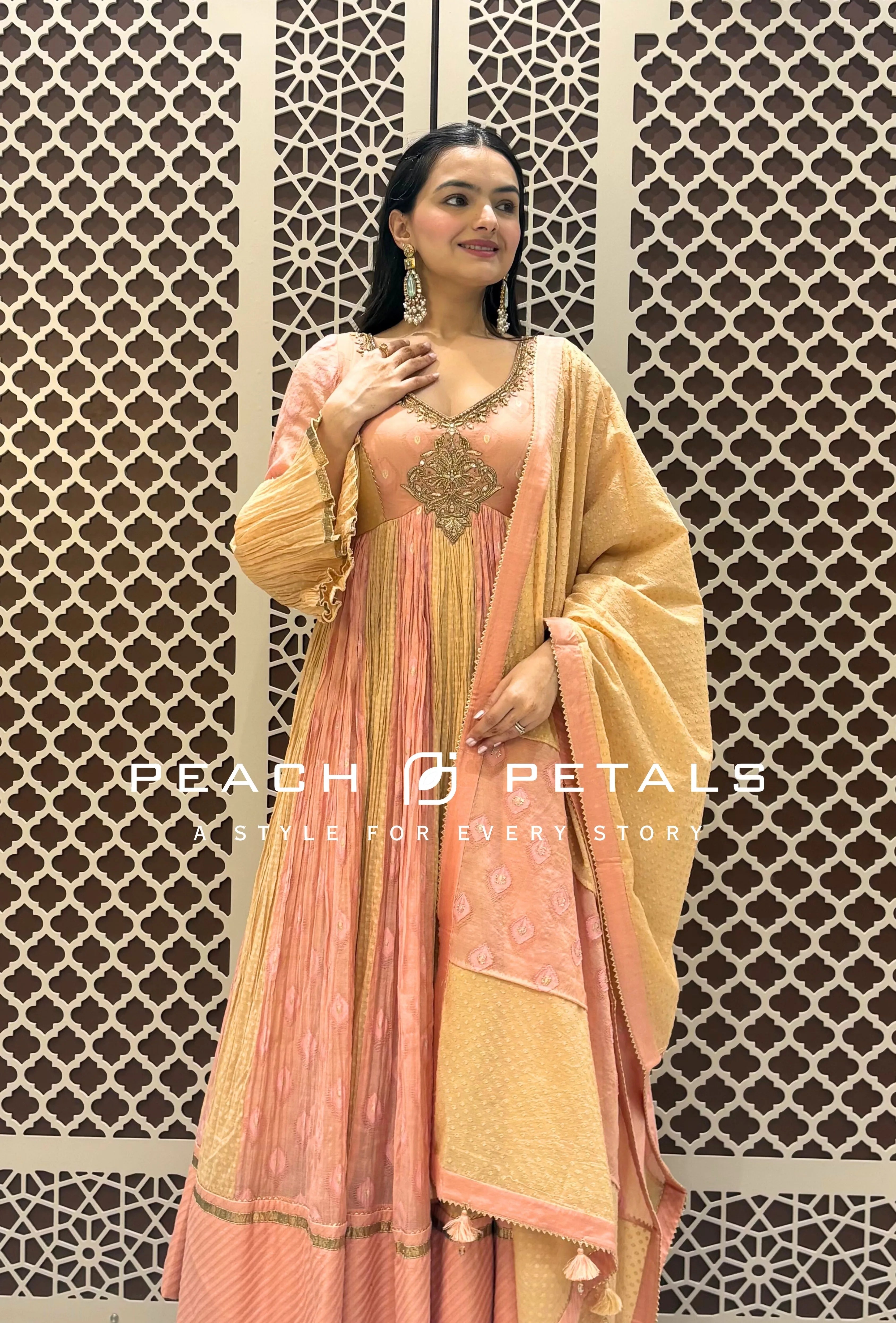 Peach and gold silk checkered Anarkali suit with heavy neckline embroidery and tassel-bordered matching dupatta.