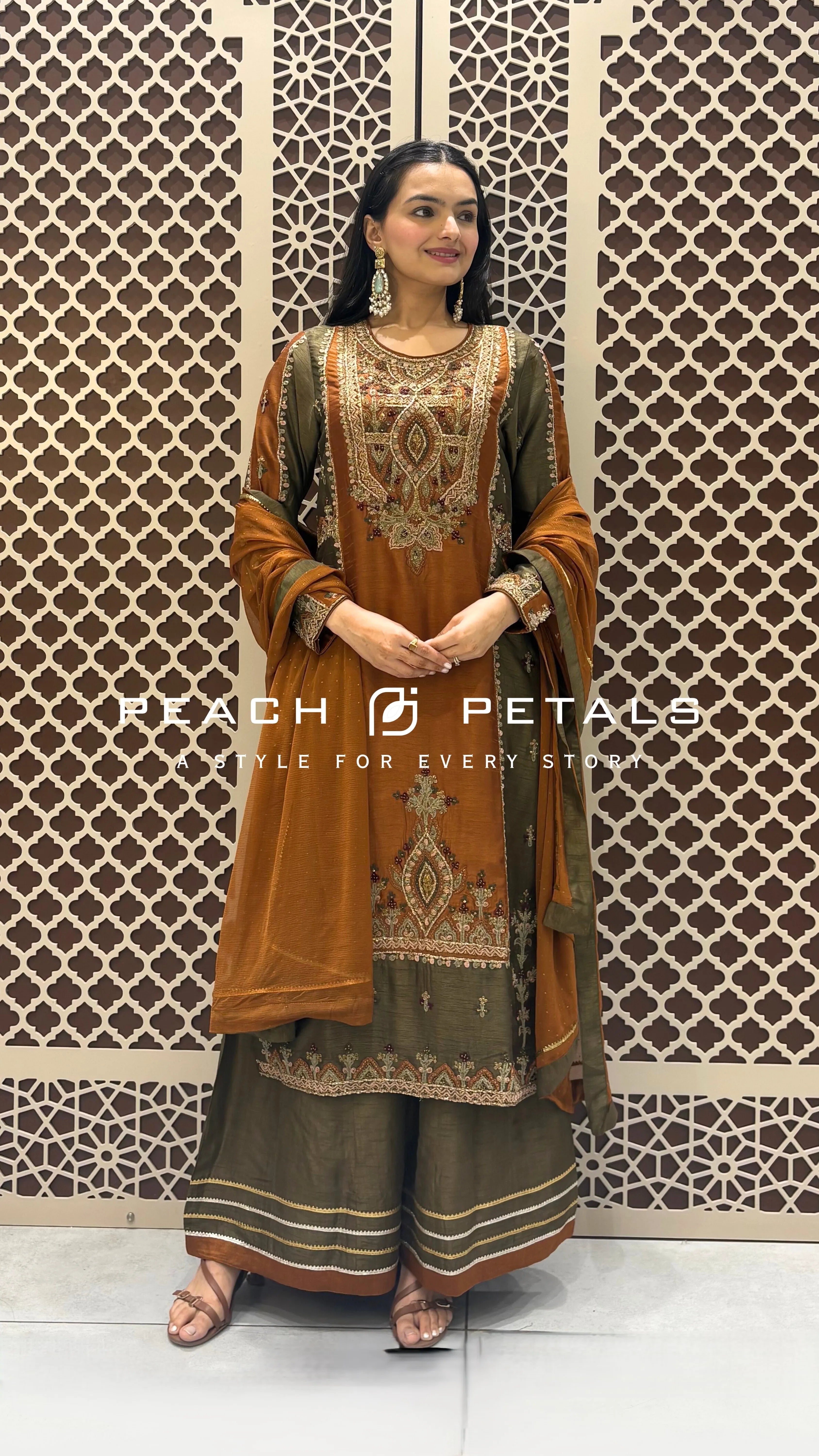 Silk checkered ethnic suit with heavy neck embroidery, olive green sharara, and rust orange dupatta.