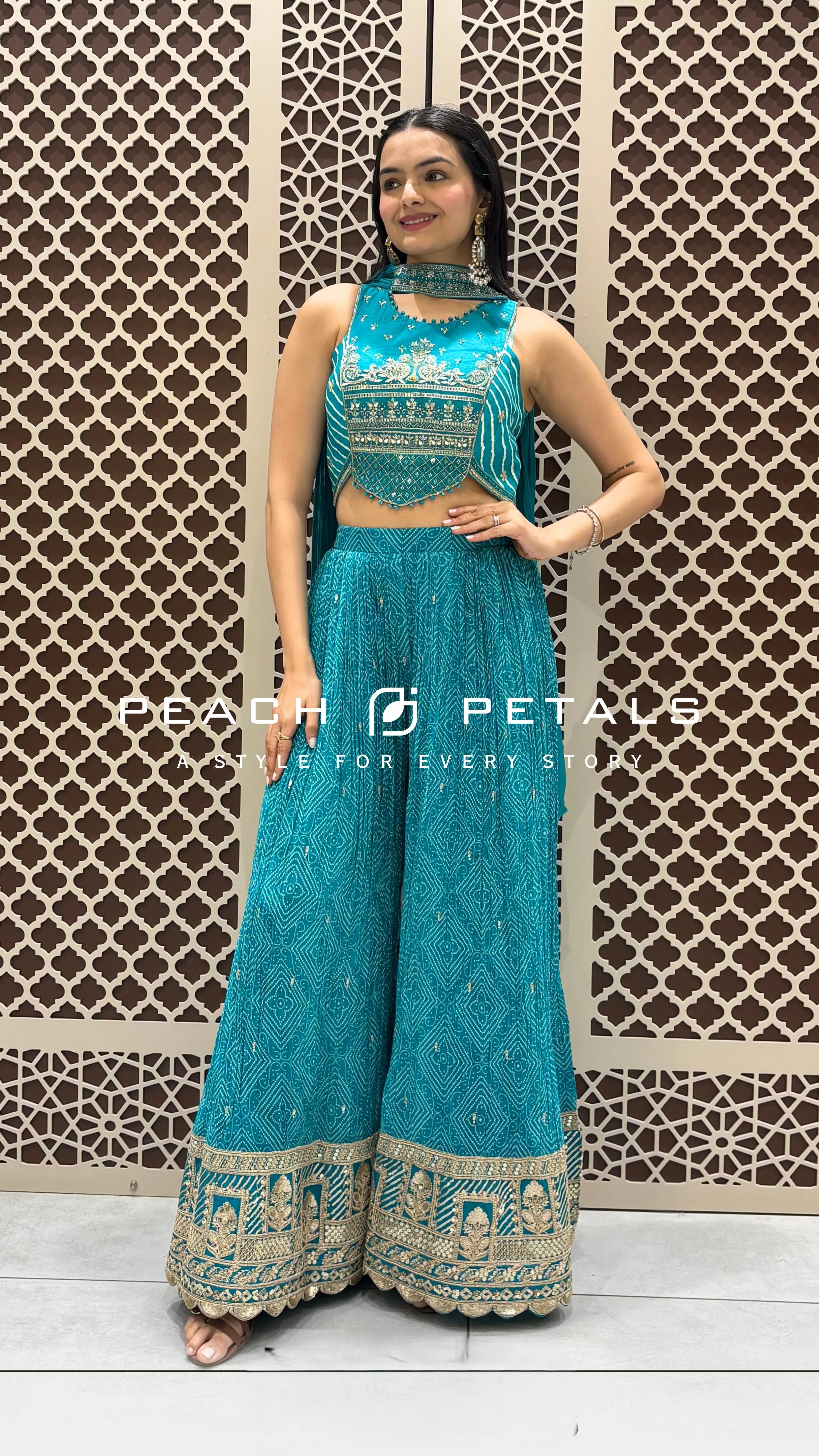 Teal bandhani print crop top with silver embroidery paired with matching flared palazzos and dupatta.