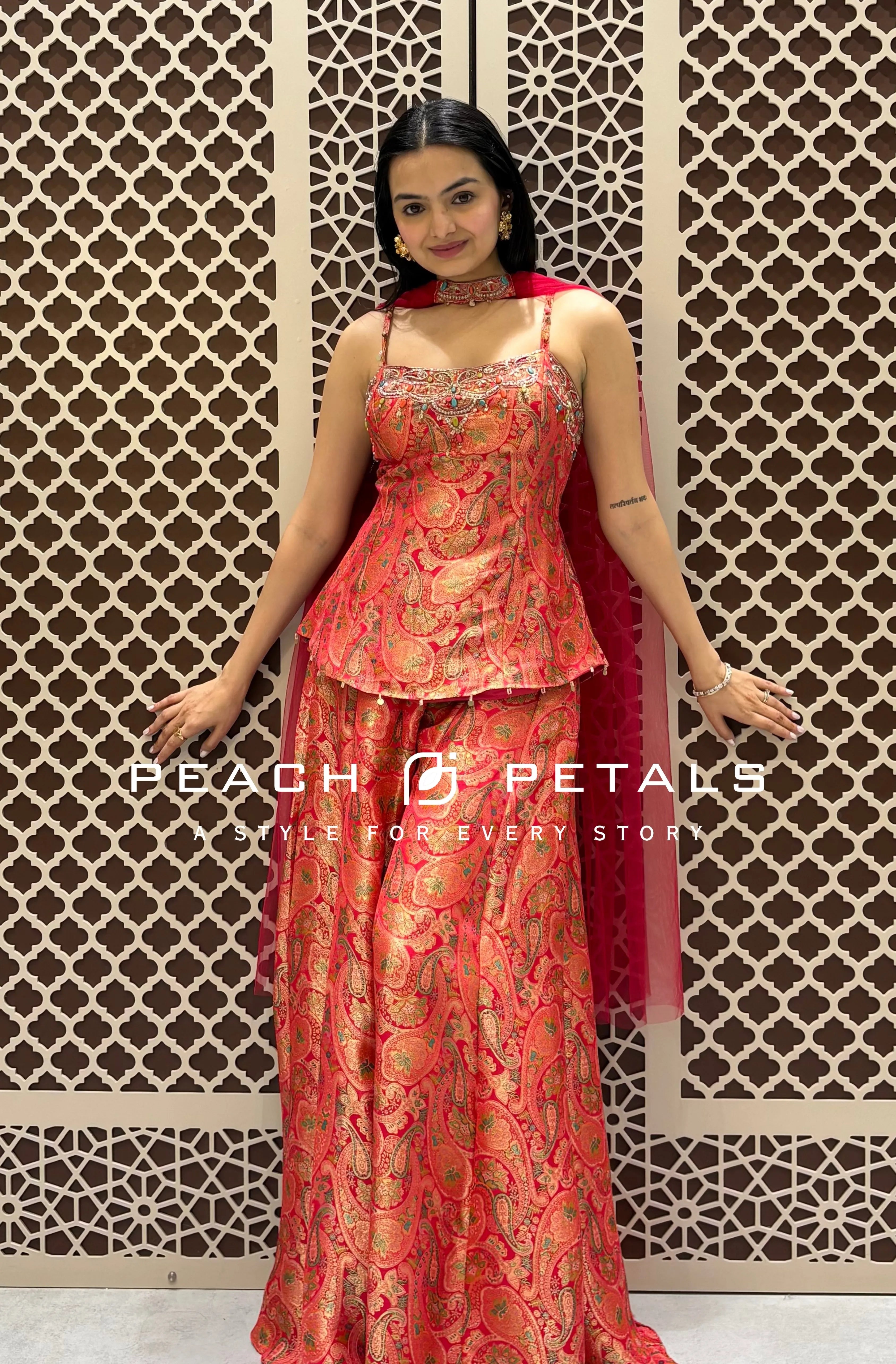 Red strappy peplum top with traditional Banarasi paisley weave and matching wide-leg flared palazzo pants.