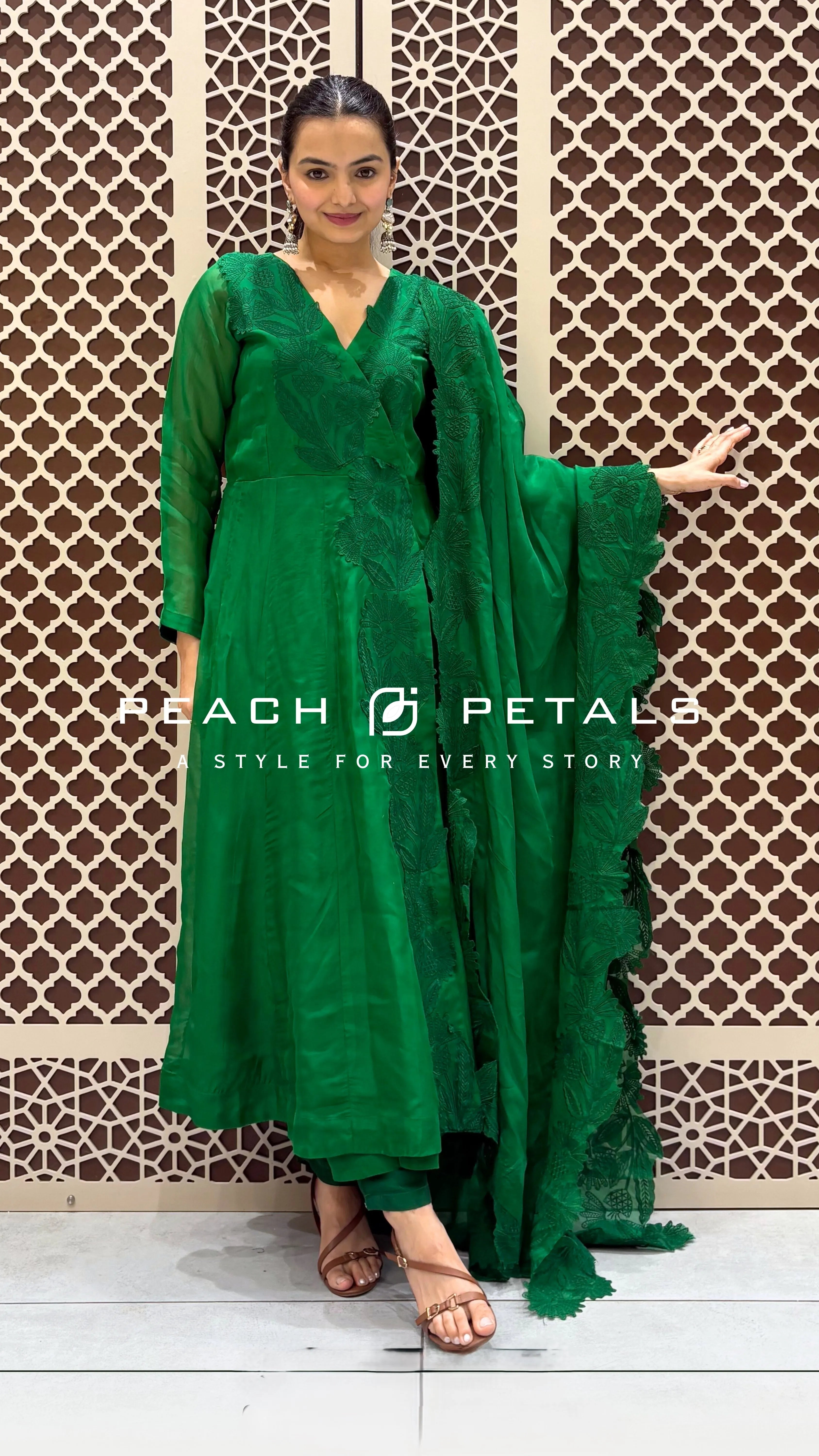 Vibrant green Anarkali suit featuring tonal floral embroidery and a matching veil with scalloped lace borders.