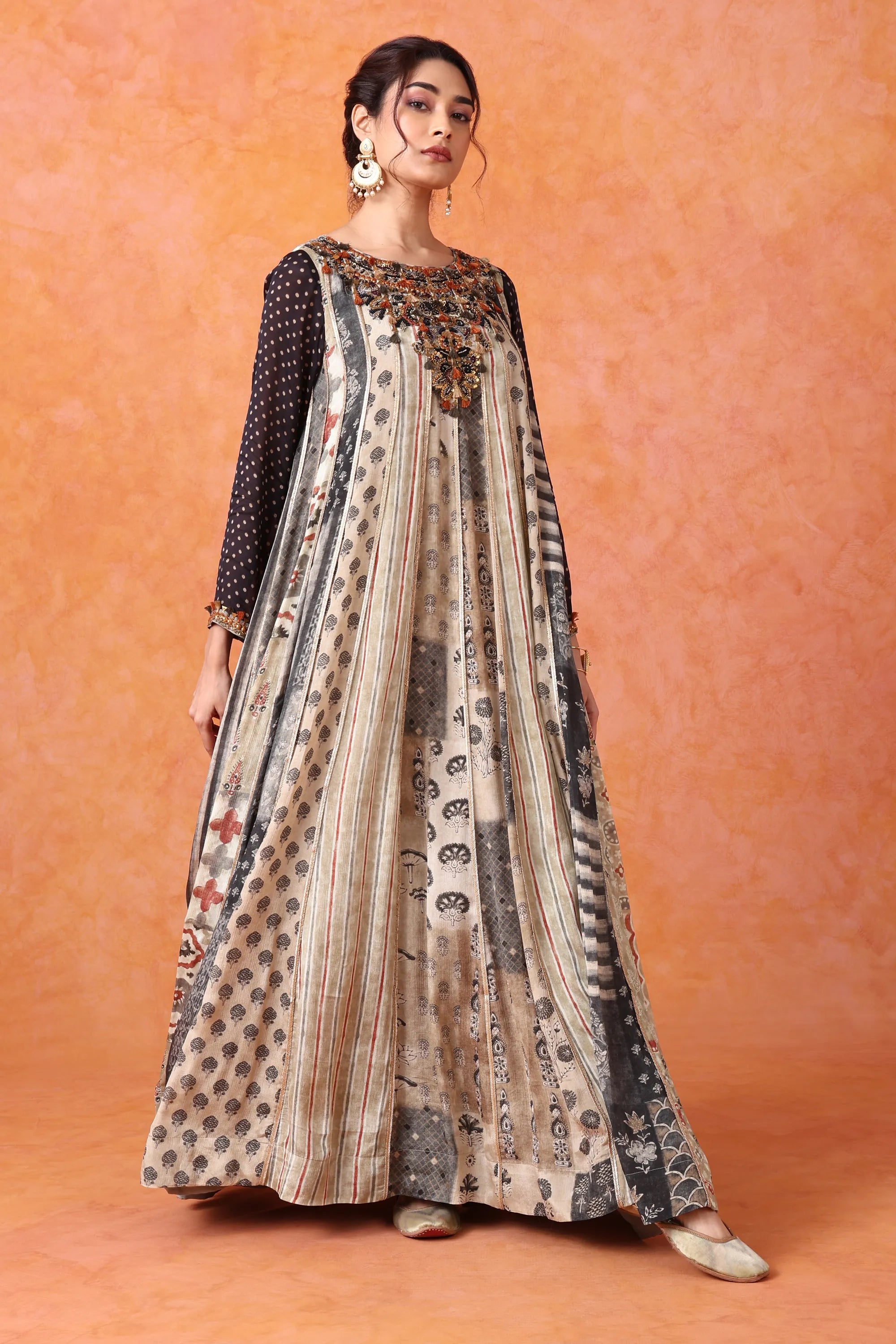 Woman wearing a patterned dress against an orange background