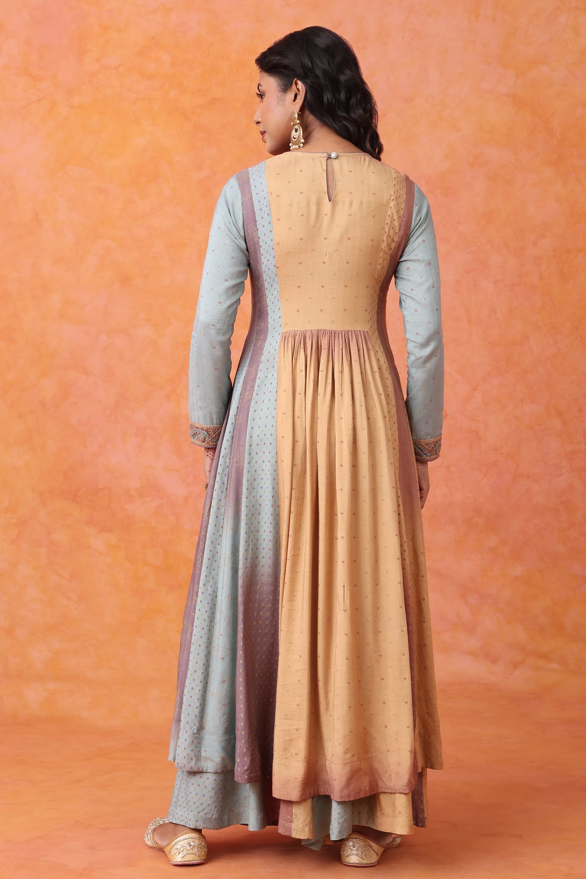 Woman wearing a two-tone dress with a gradient from gray to beige on an orange background