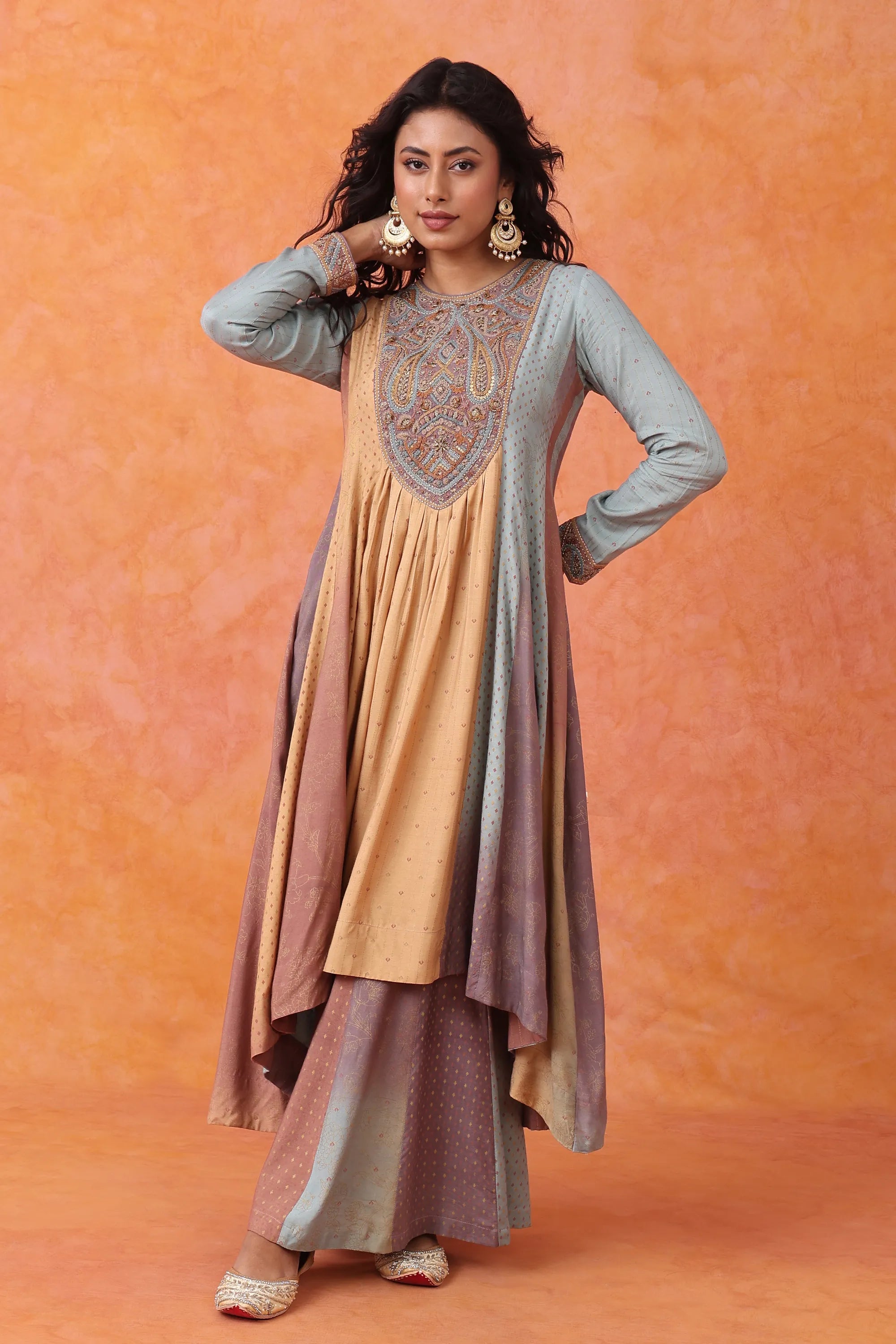 Woman wearing a traditional outfit with a gradient of colors against an orange background