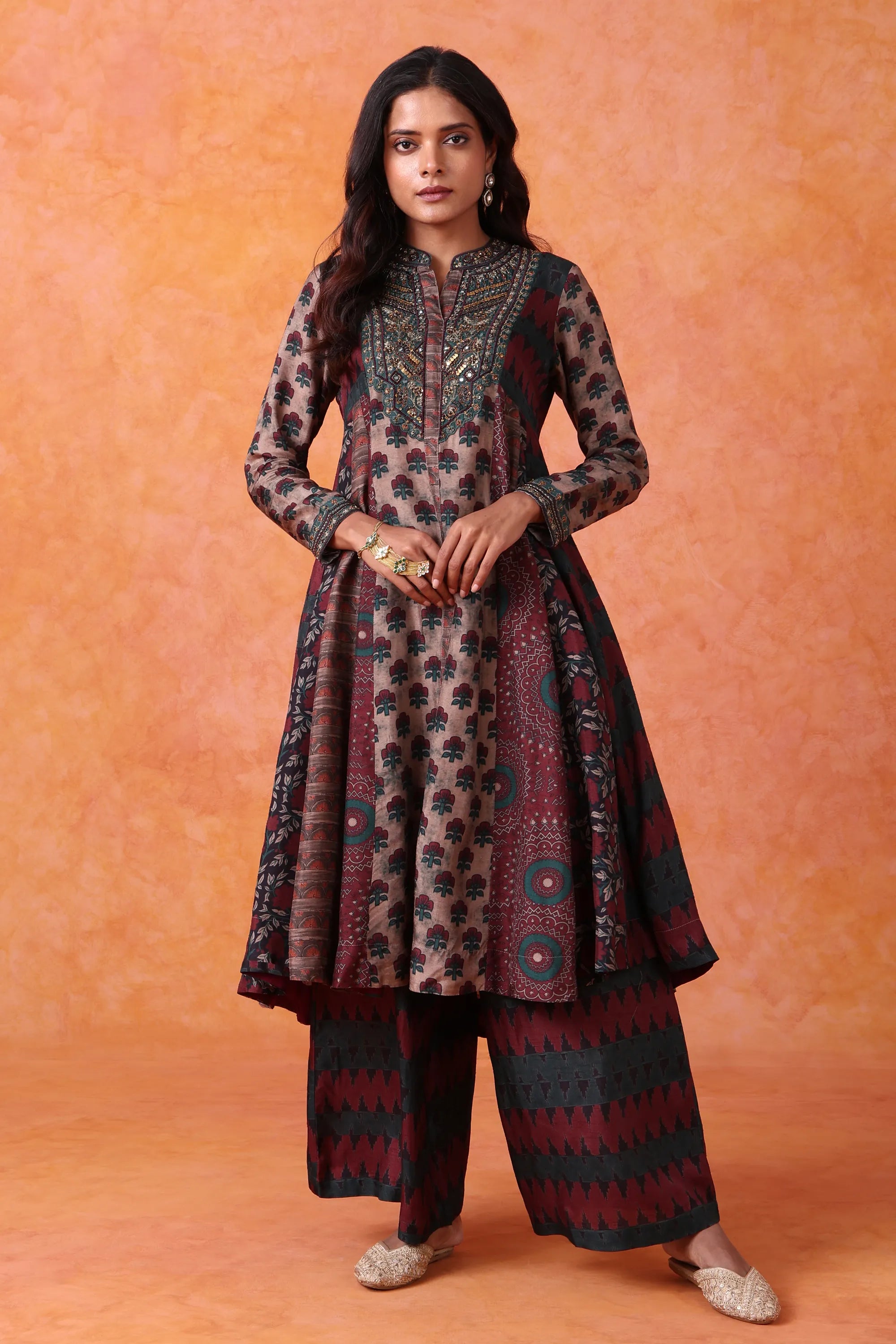 Woman wearing a patterned outfit against an orange background