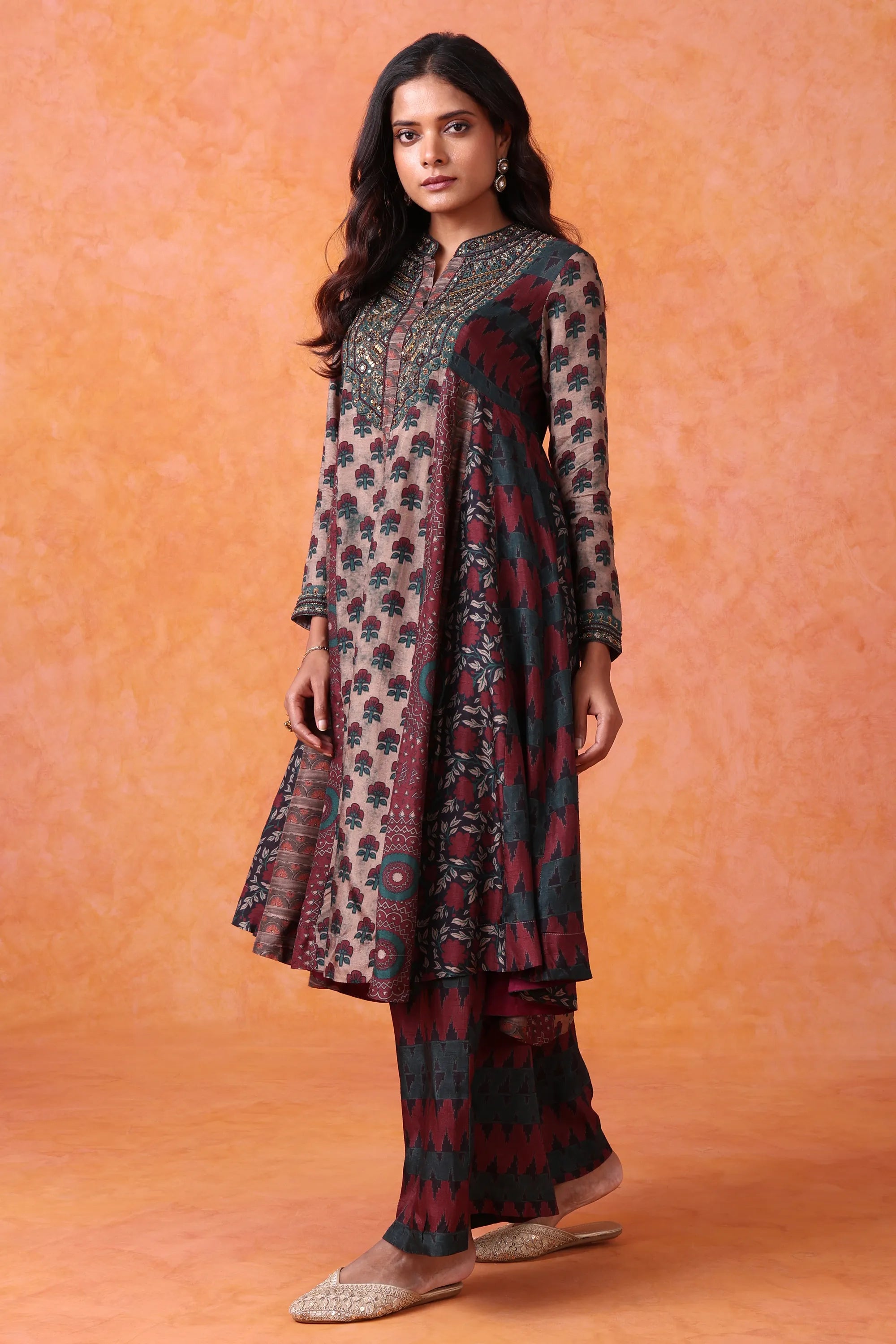 Woman wearing a patterned outfit against an orange background