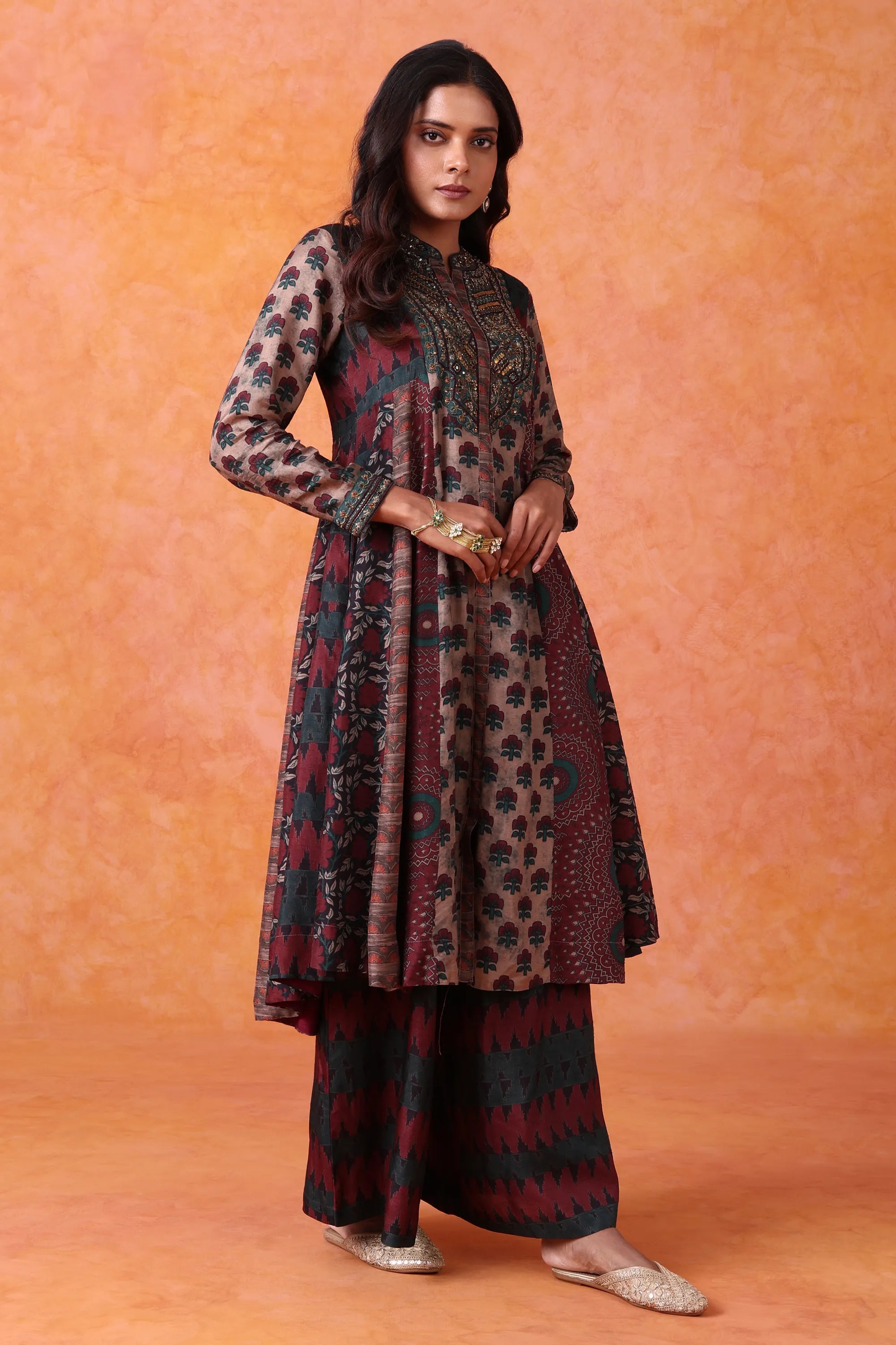 Woman wearing a patterned outfit against an orange background