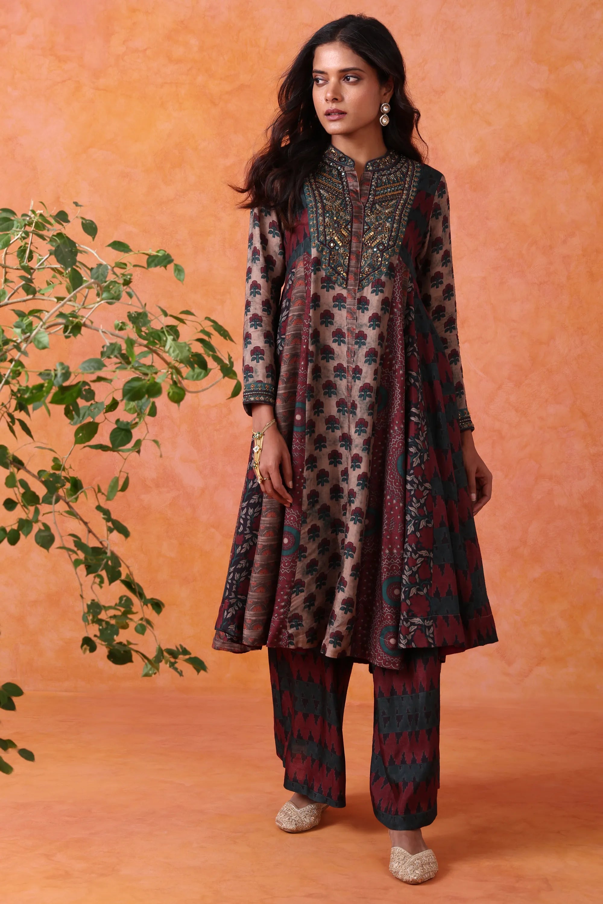 Woman wearing a patterned outfit against an orange background