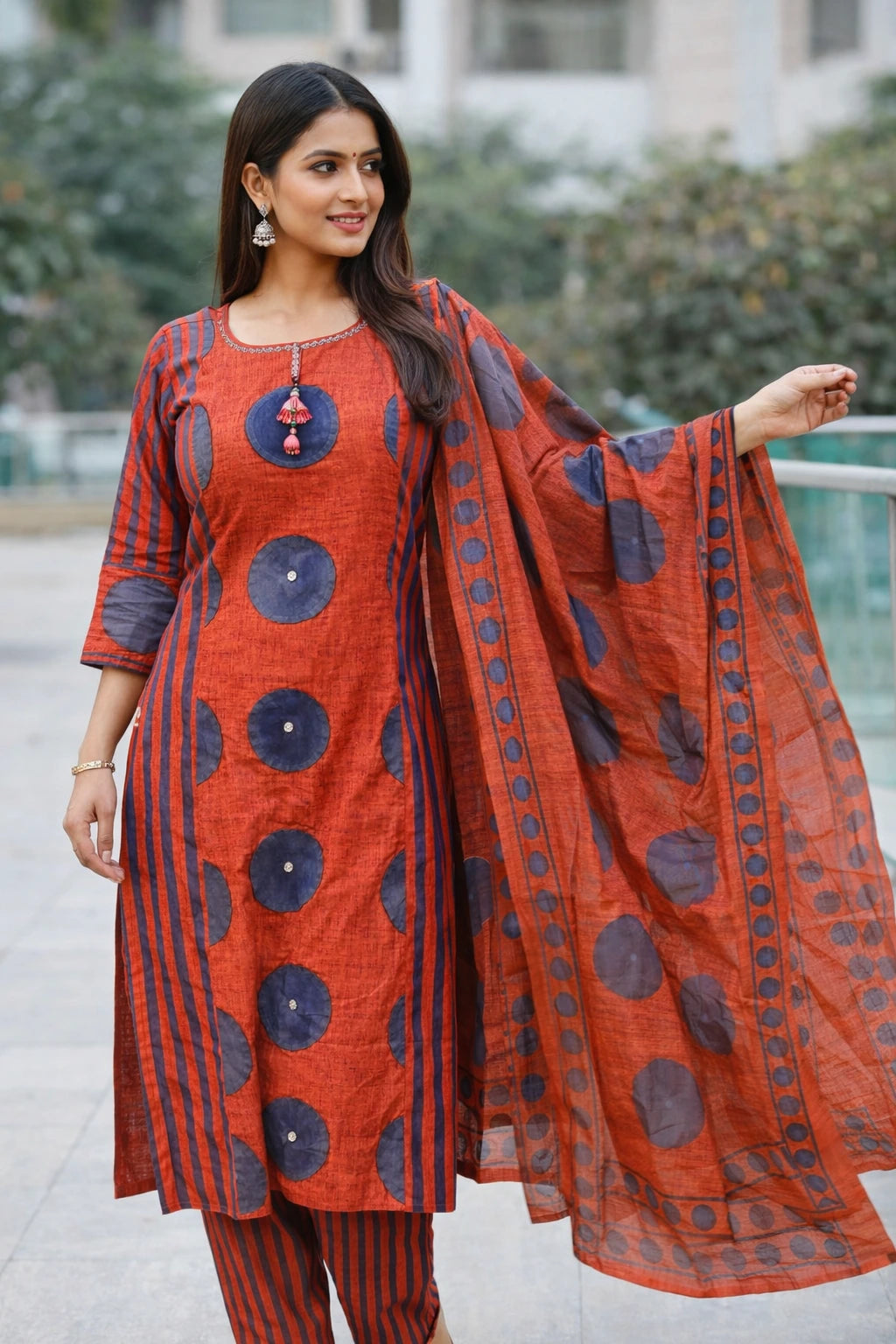 Woman wearing a red and blue patterned outfit outdoors.