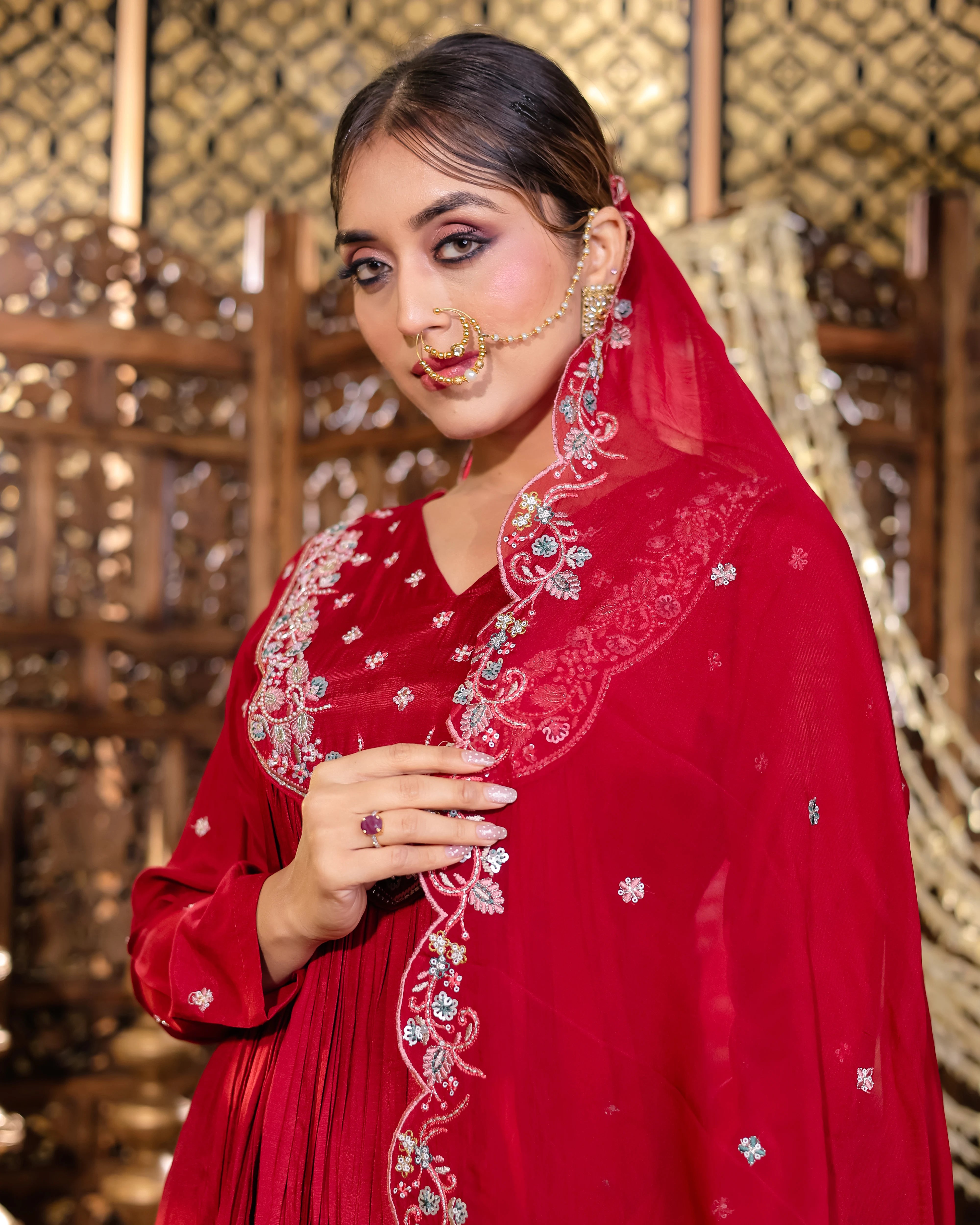 Woman wearing a red embroidered traditional outfit with a gold background