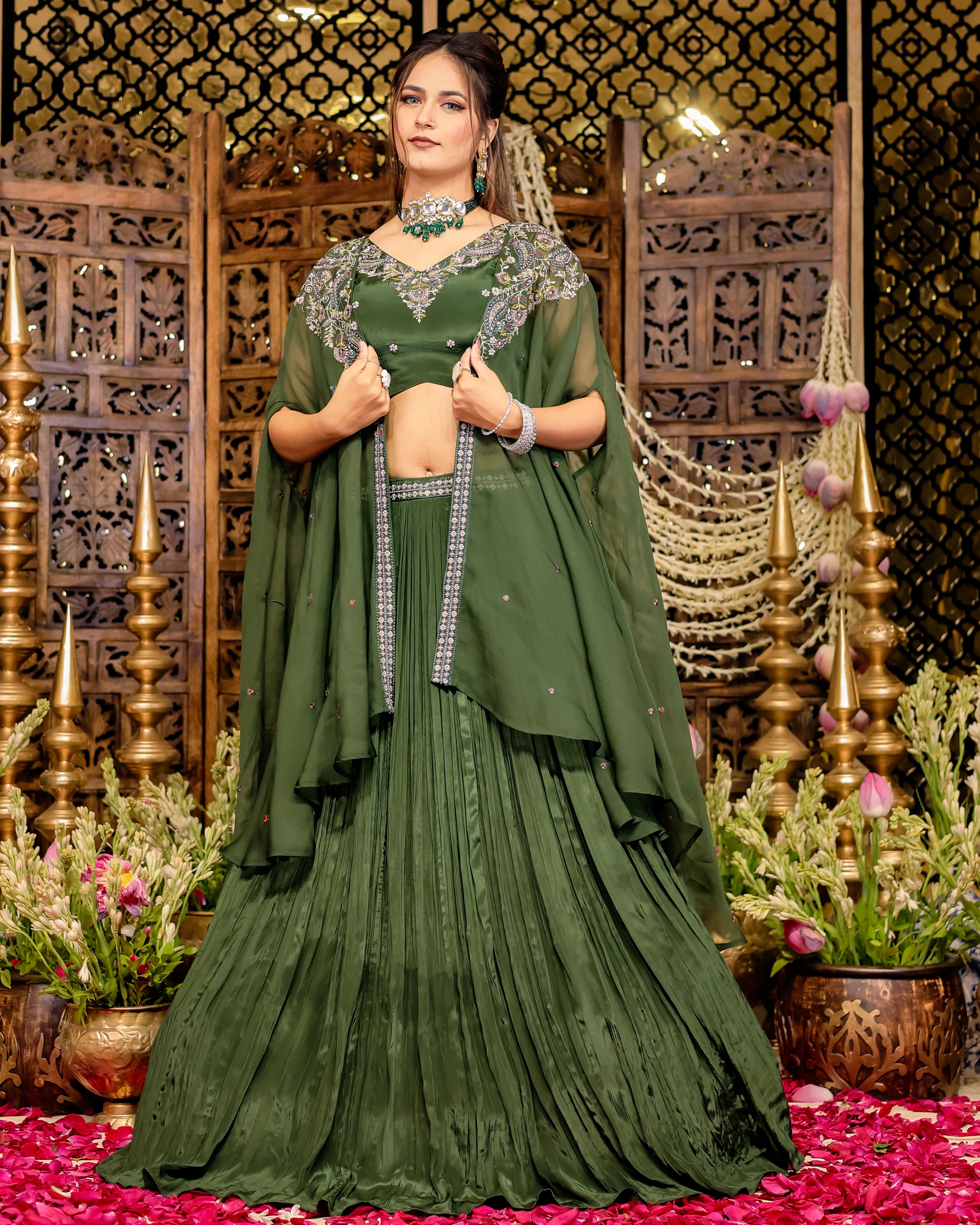 Deep olive green pleated lehenga with an intricately embroidered blouse and a matching cape dupatta.