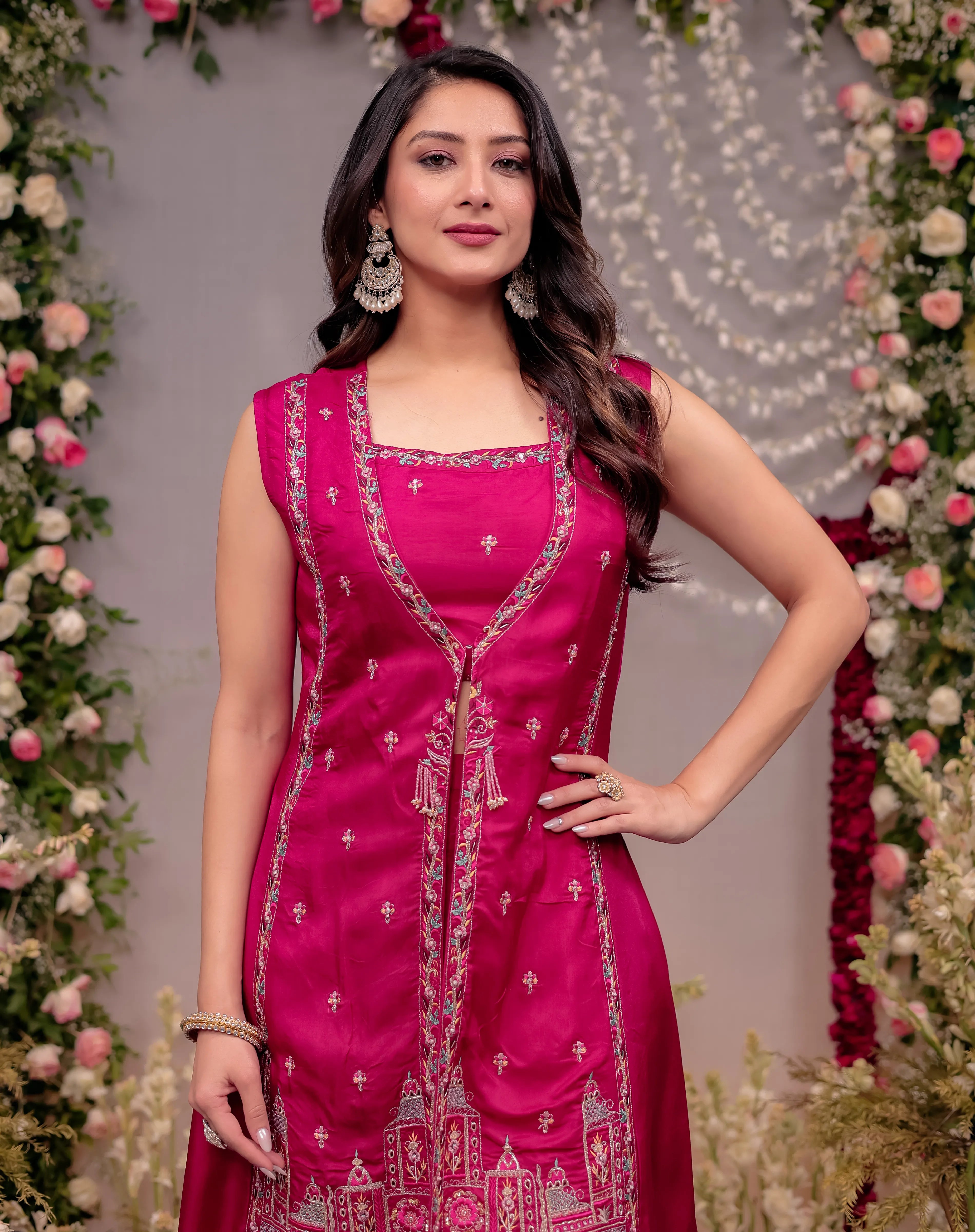 Woman in a pink traditional outfit with floral decorations in the background