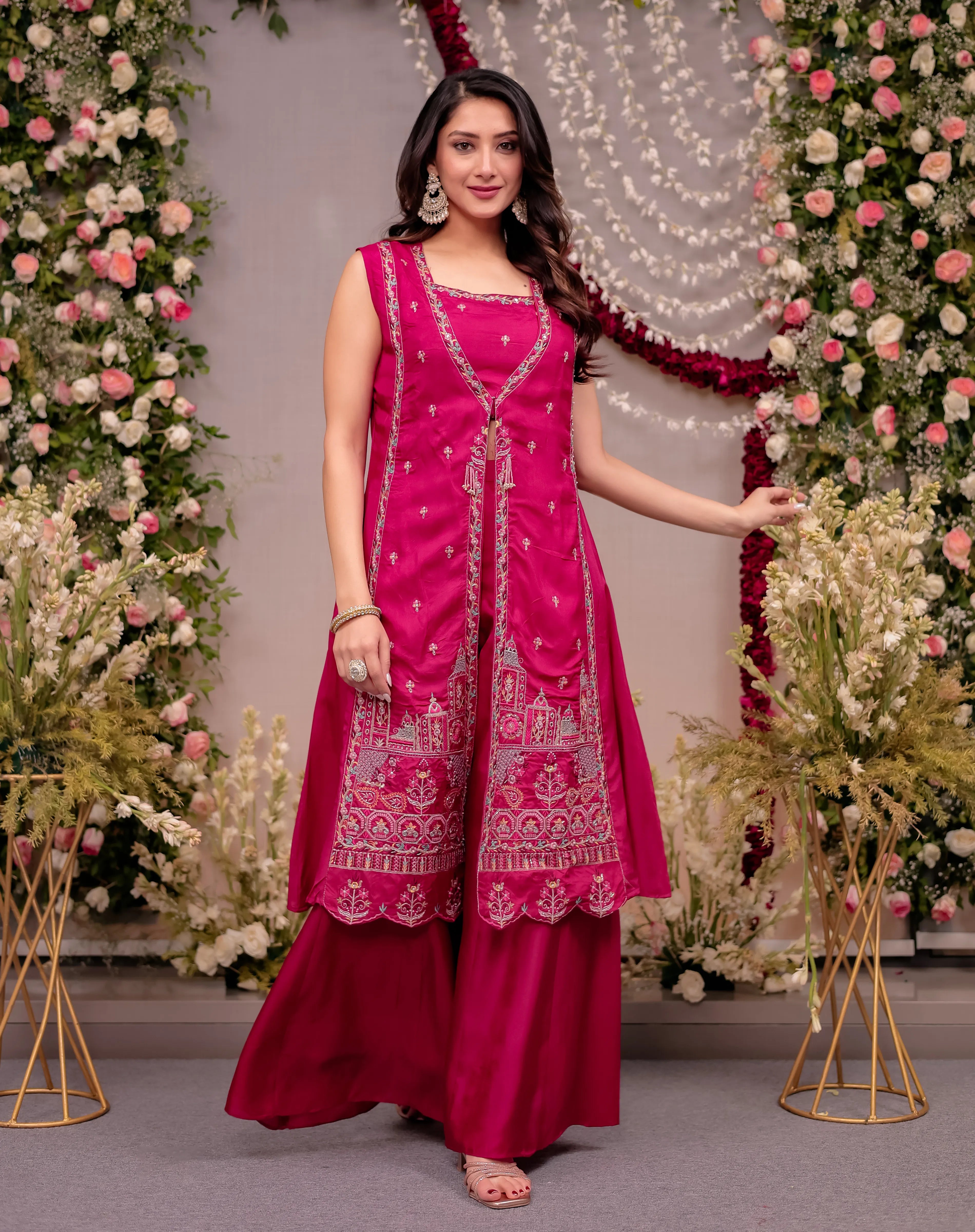 Woman in a pink traditional outfit with floral decorations in the background