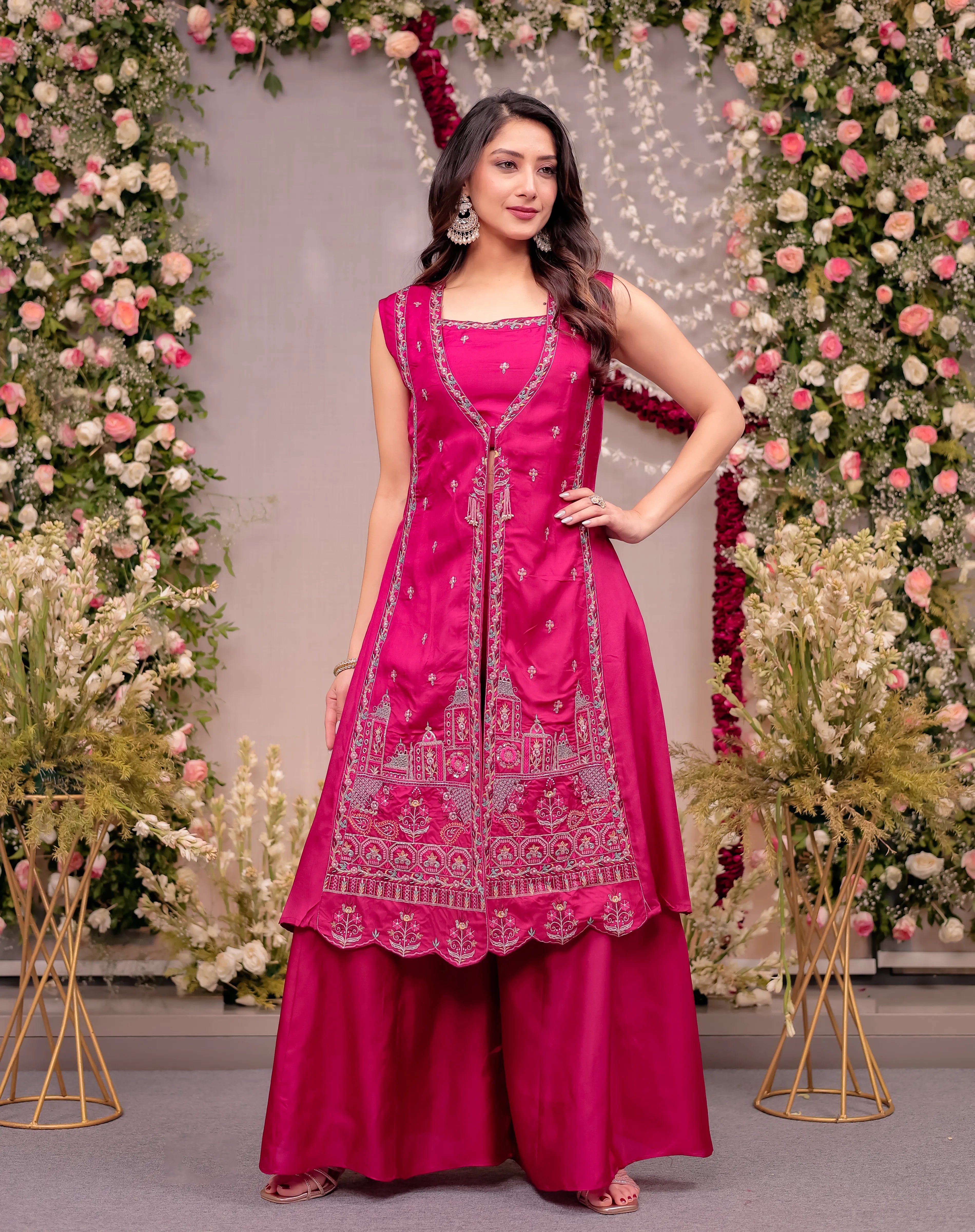 Woman in a pink traditional outfit with floral decorations in the background