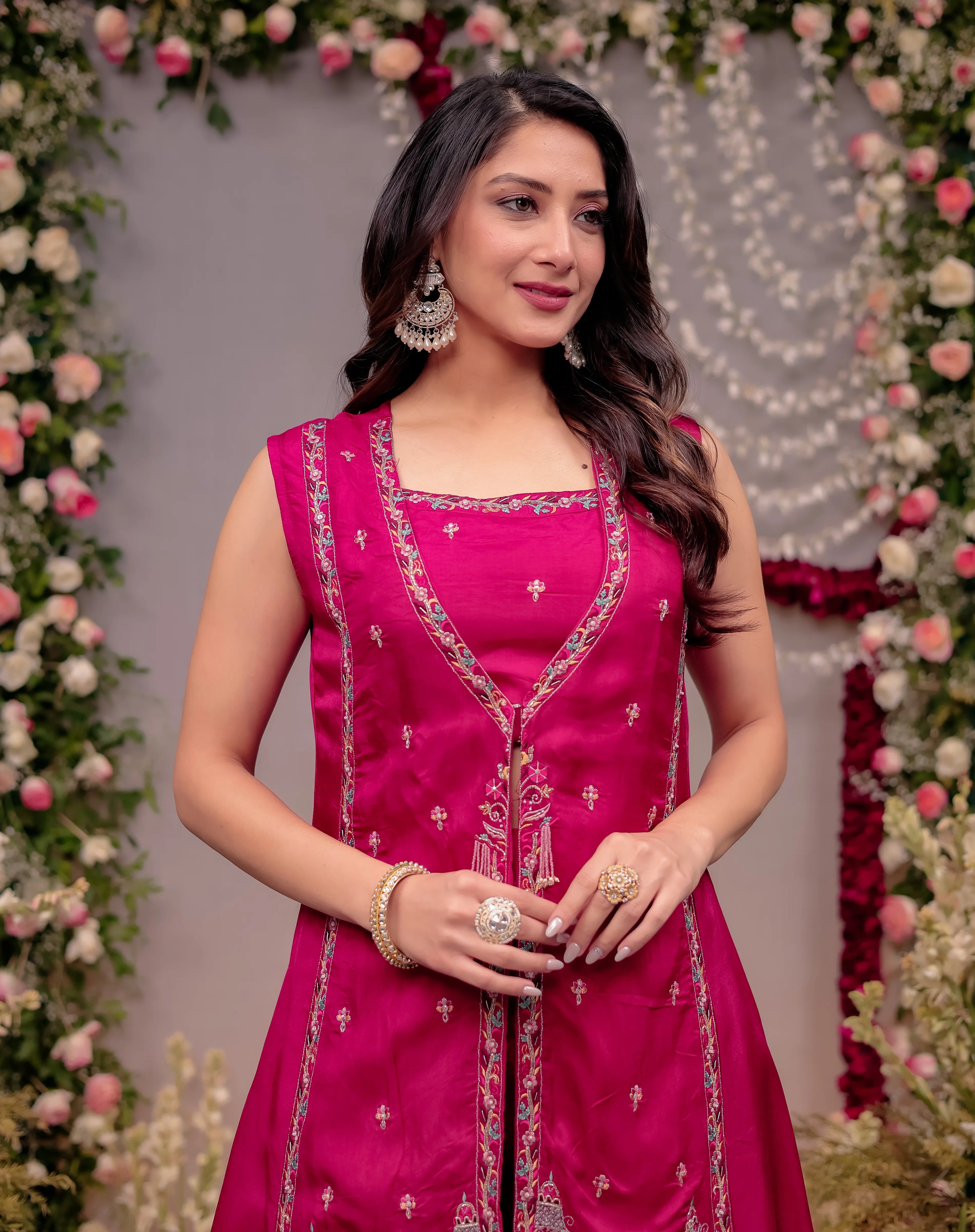 Woman in a pink traditional outfit with floral decorations in the background