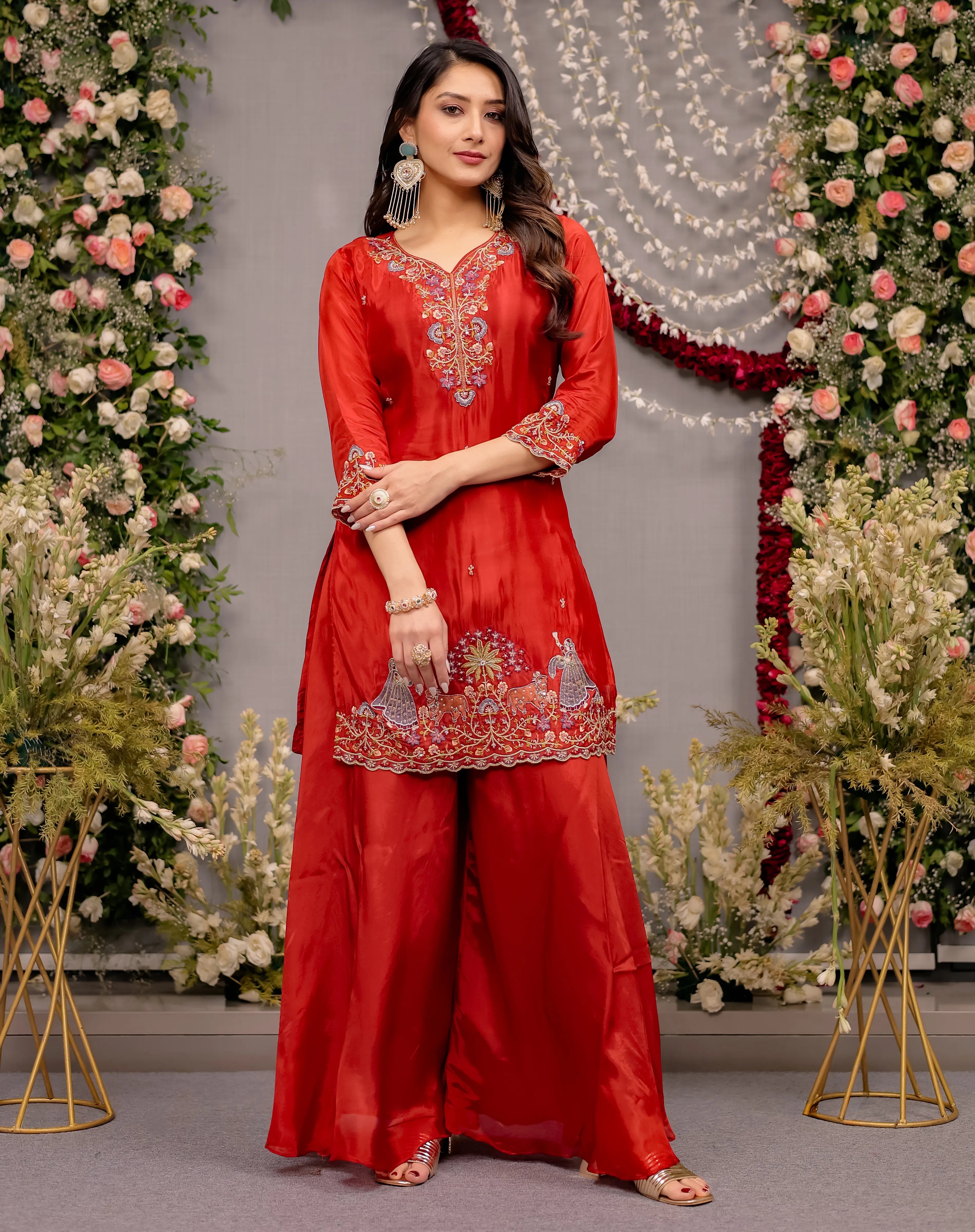 Woman in a red traditional outfit with floral decorations in the background