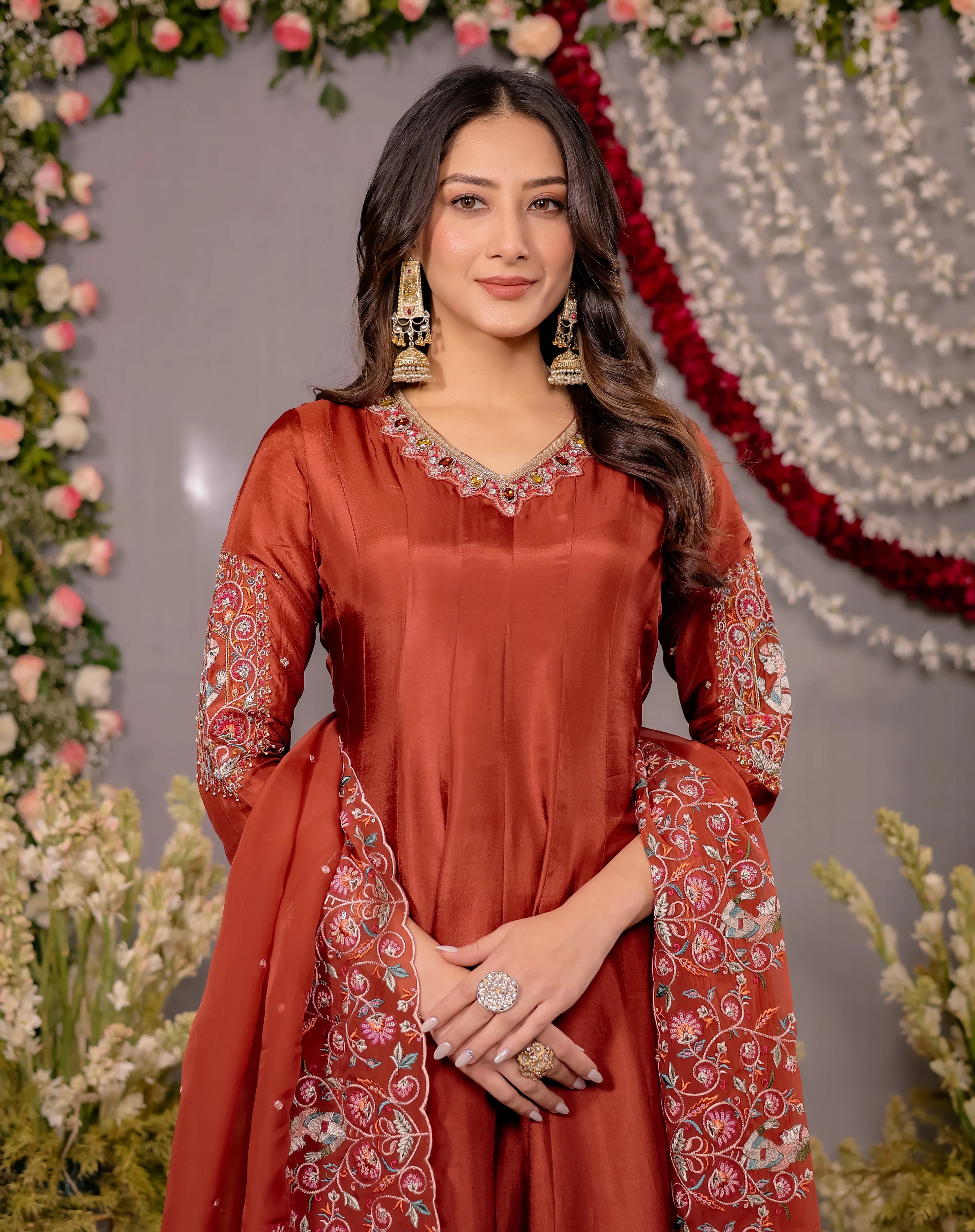 Woman in a traditional red outfit with floral decorations in the background