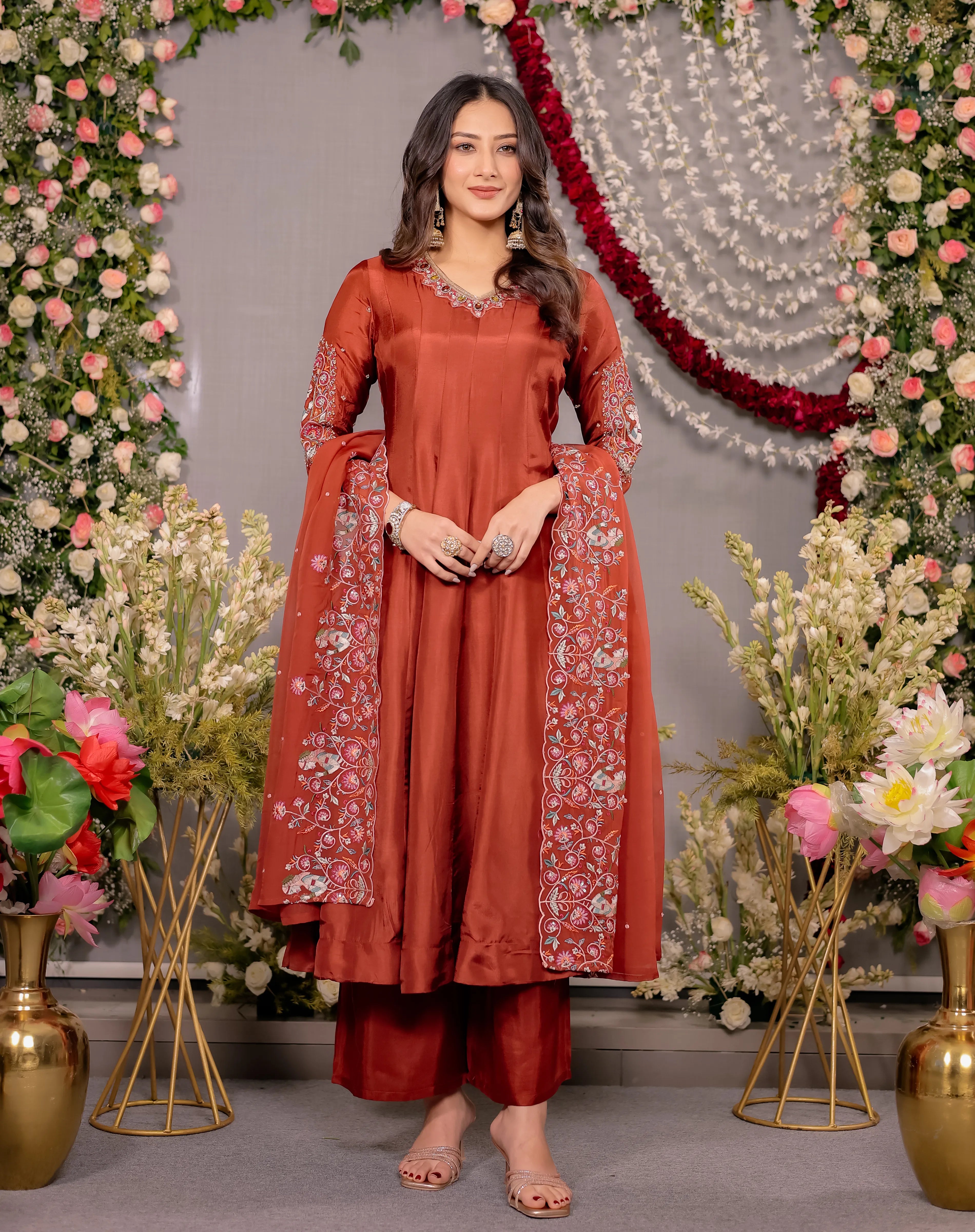 Woman in a red traditional outfit with floral decorations in the background