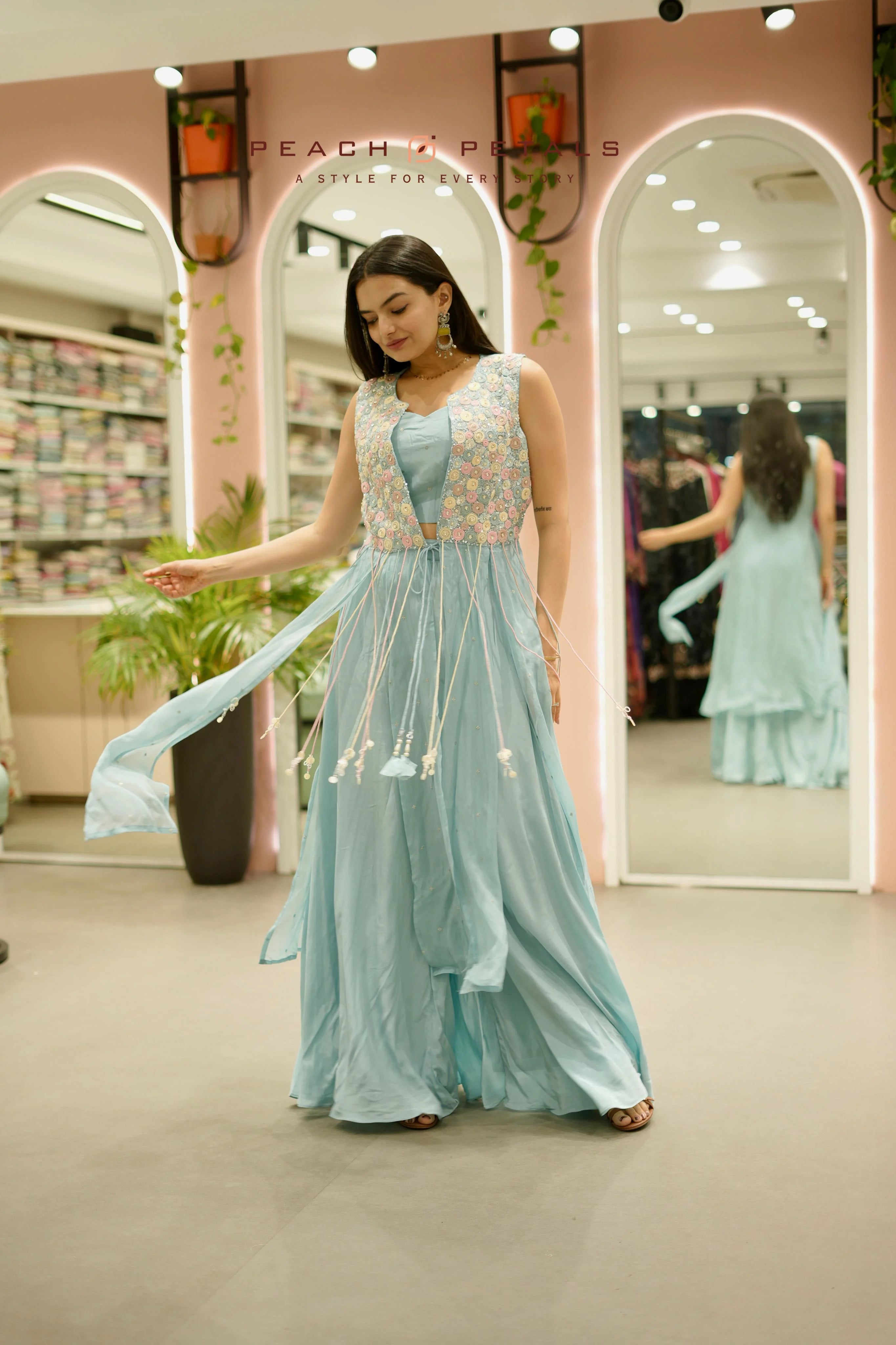 A three-piece Indo-western outfit featuring a crop top, flared palazzos, and a floral embroidered shrug.