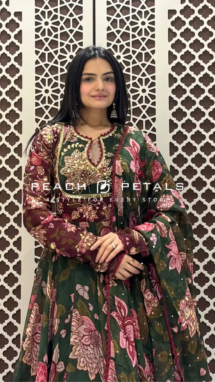 Dark green floor-length Anarkali featuring pink floral prints and a heavily embroidered sequin bodice detail.
