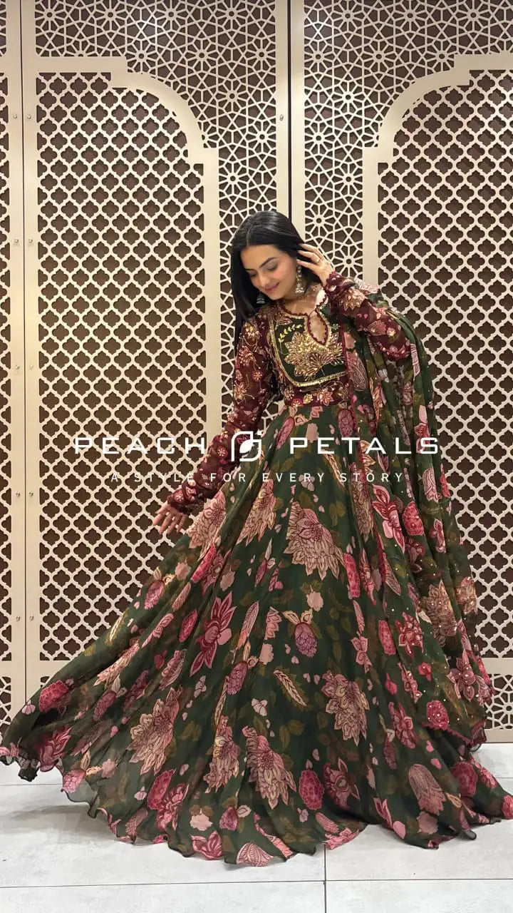 Dark green floor-length flared Anarkali with pink floral prints, maroon embroidered sleeves, and a matching dupatta.