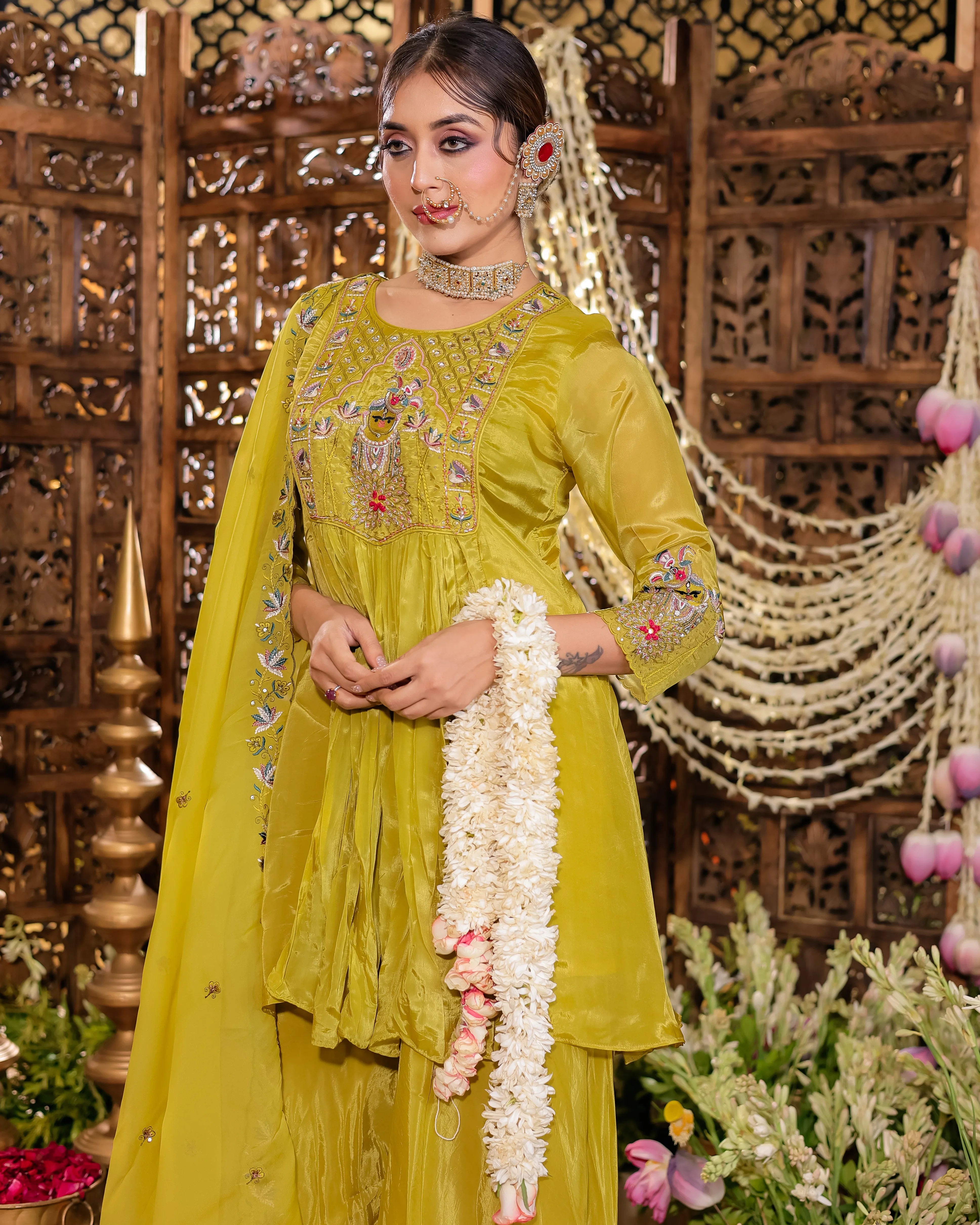 Lime green ethnic suit featuring intricate colorful embroidery, matching dupatta, and a flared tunic with traditional silver jewelry accents.