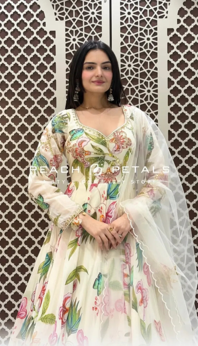 Cream-colored Indo-Western gown featuring vibrant pastel floral prints, long sleeves, and a matching sheer scalloped dupatta.