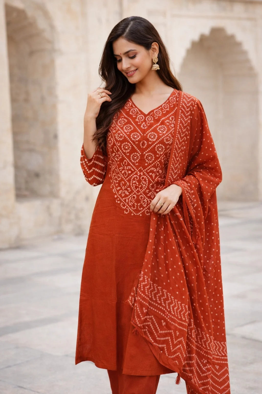 Ethnic burnt orange kurta featuring intricate white patterns, matching trousers, and a coordinating lightweight printed dupatta.